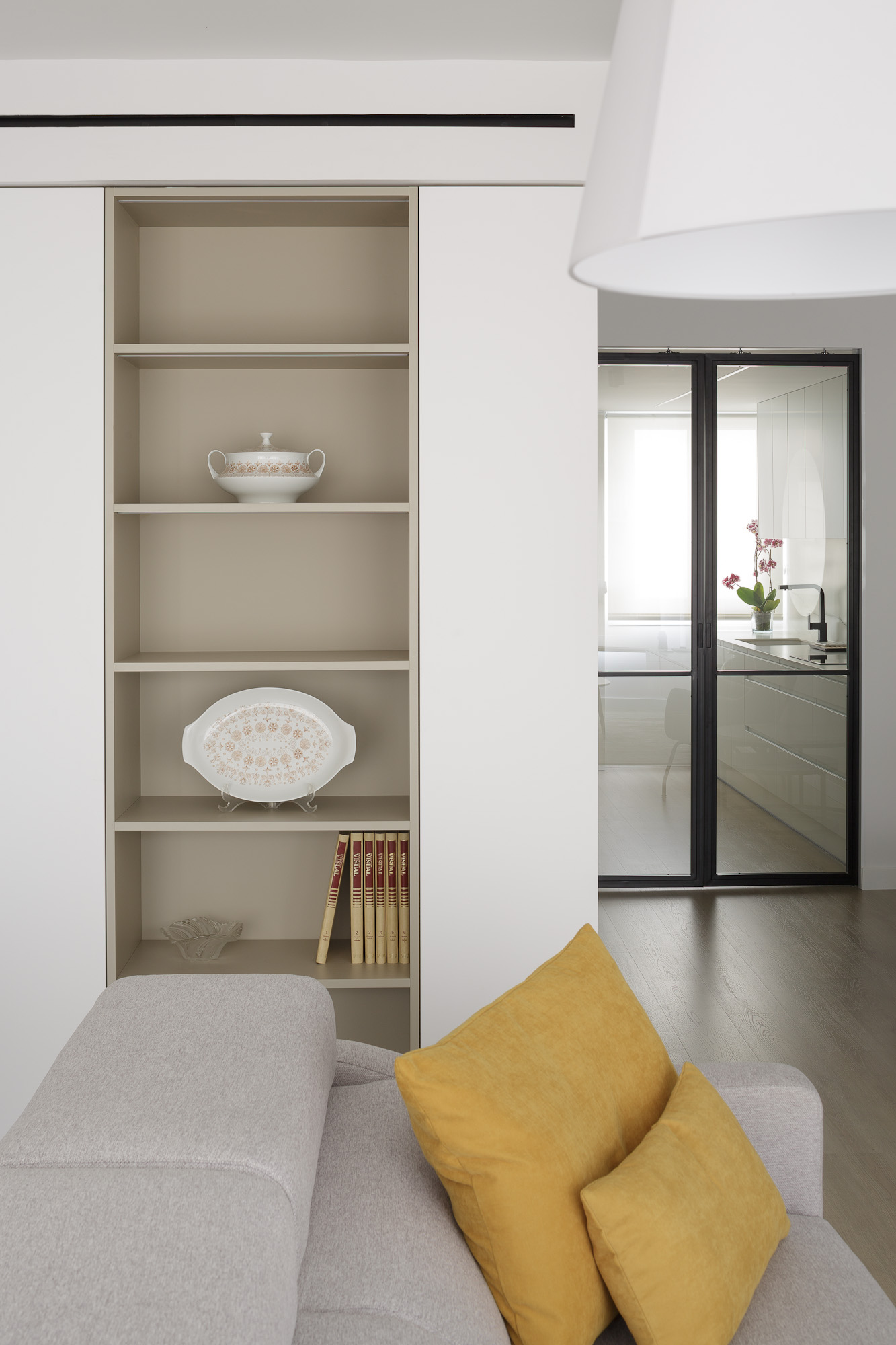 Detalle de la estantería a medida con las puertas de vidrio de la cocina cerradas